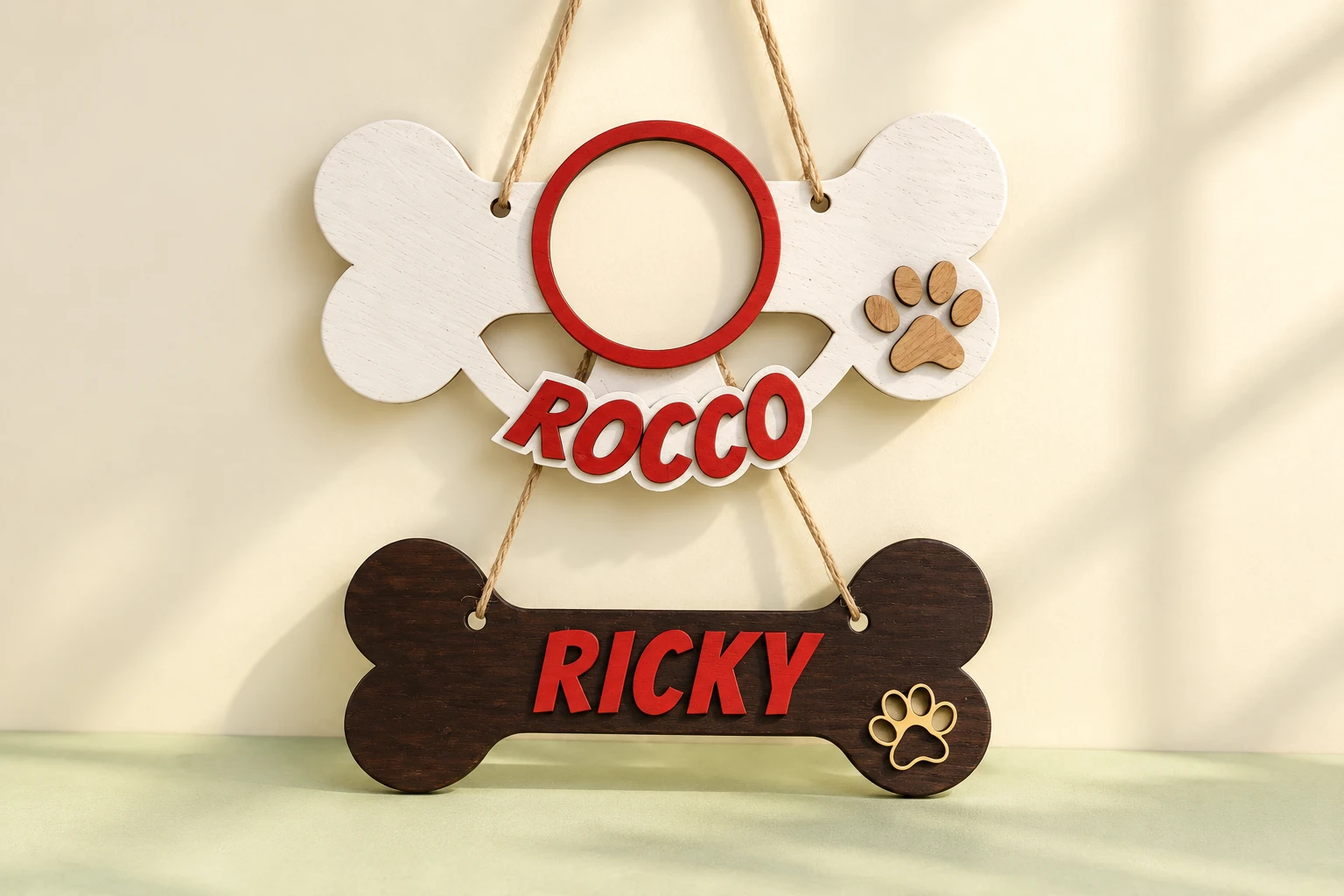 Dos adornos de madera con forma de hueso y nombres de mascotas